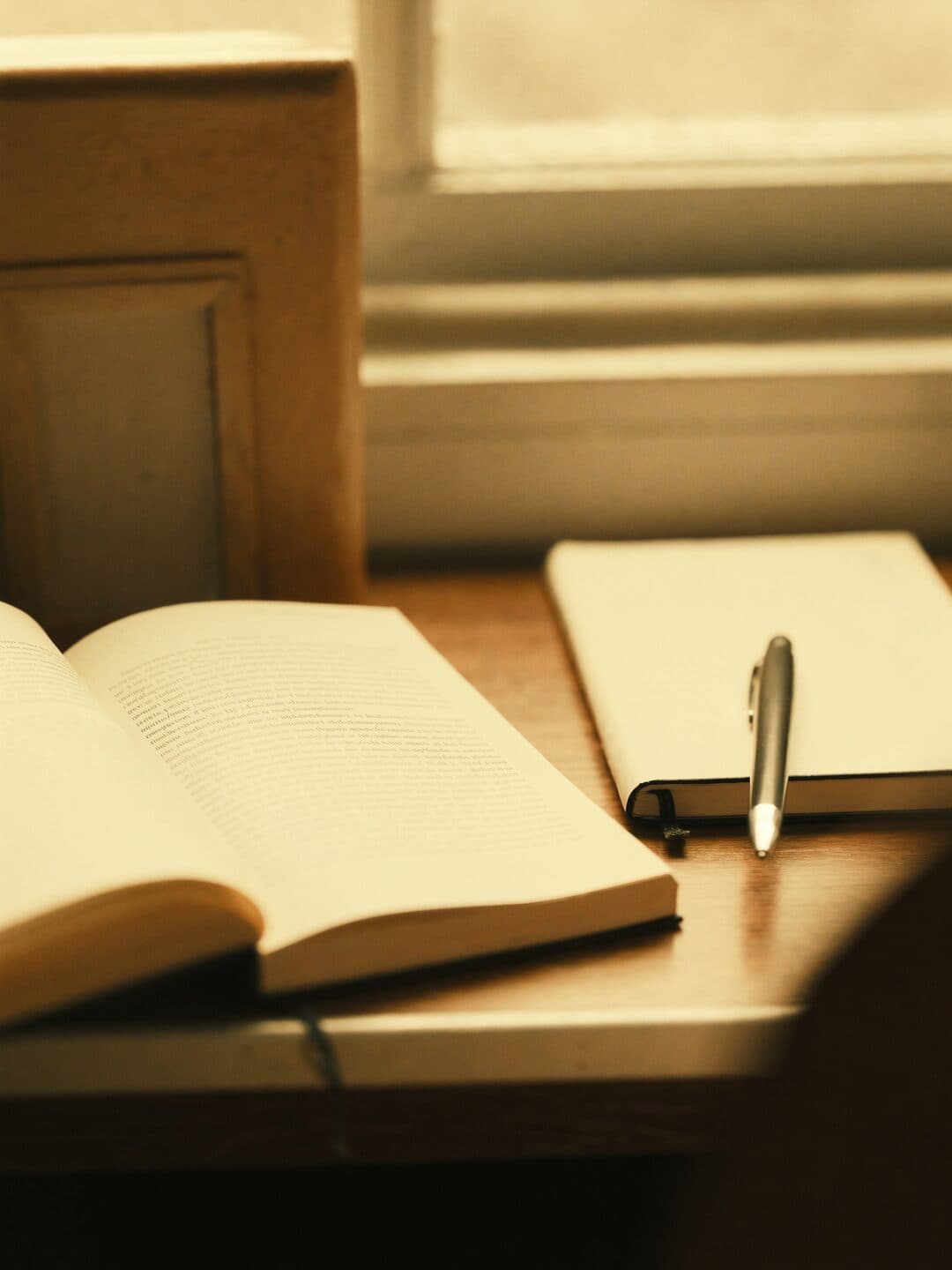 An open journal and book on a desk